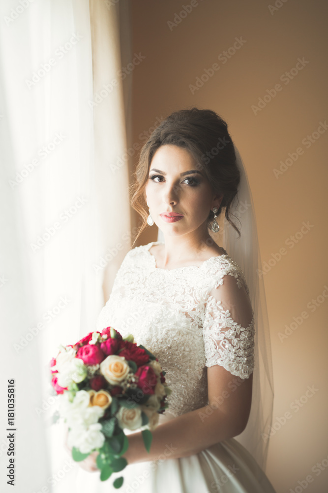 Luxury bride in white dress posing while preparing for the wedding ceremony Luxury bride in white dress posing while preparing for the wedding ceremony