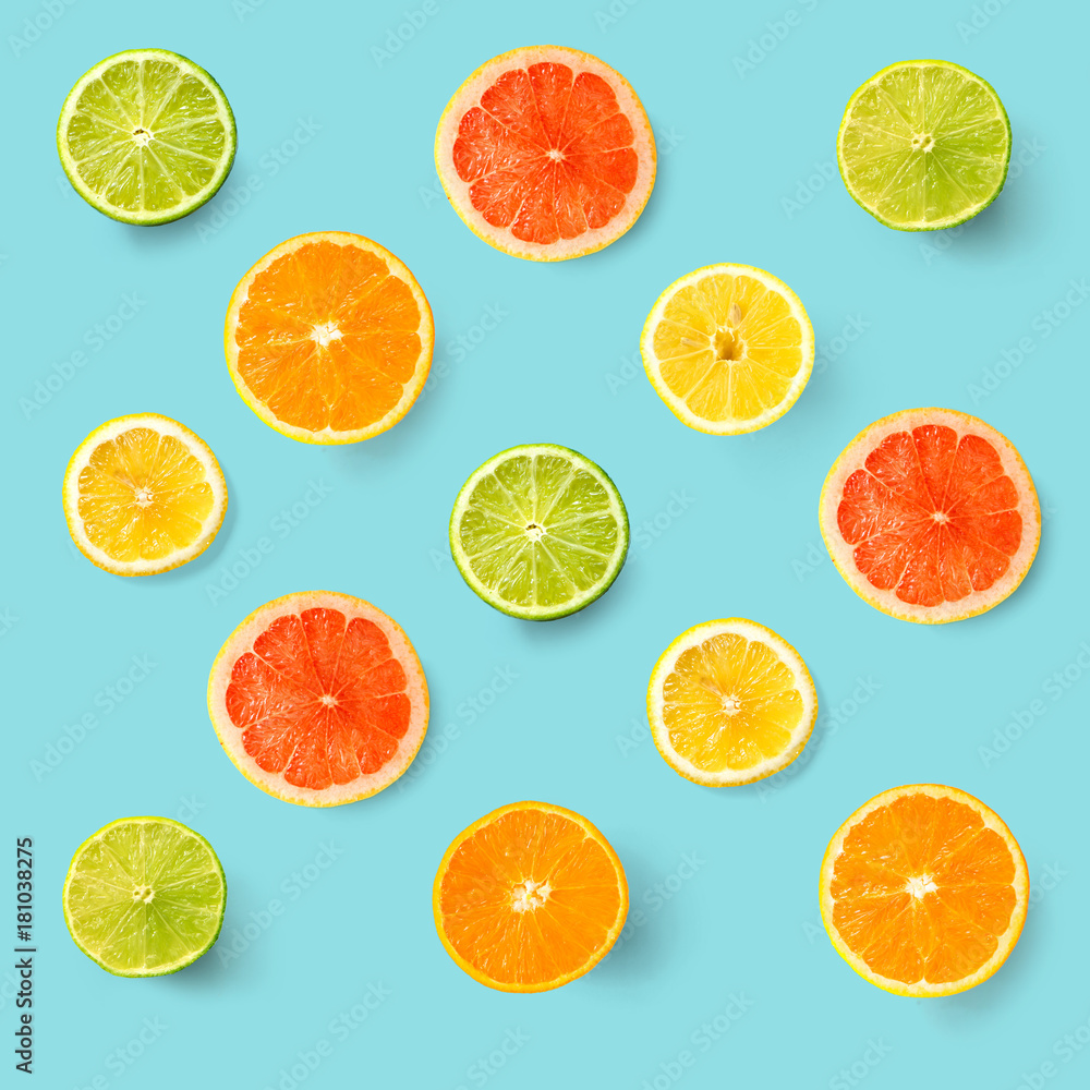 Creative layout made of lemon, lime, orange and grapefruit. Flat lay. Food concept. Lemon, lime, orange and grapefruit on turquoise background.