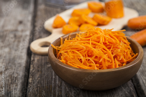 Grate carrots in a bowl