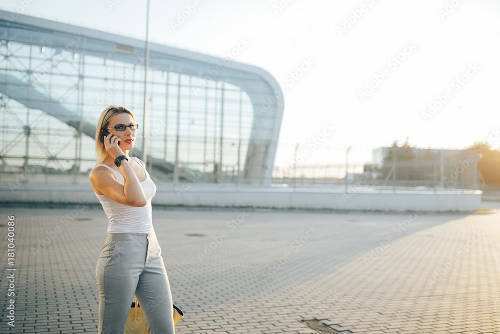 Business woman using a phone while standing in outdoor
