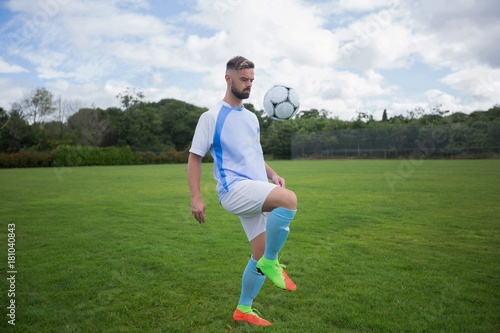 Football player juggling soccer ball