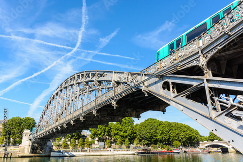 The Austerlitz viaduct in Paris, seen from the right bank of the river Seine with a metro train passing, is a single-deck, steel arch, rail bridge that was built in 1904 by the Eiffel company. photo