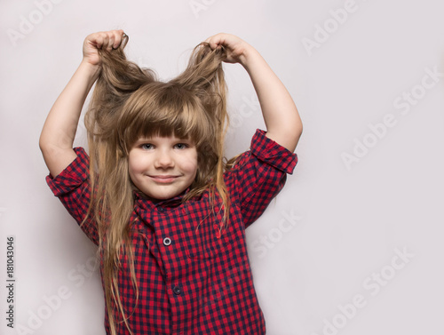 The girl lifted her hair up. The girl is dressed in a plaid shirt.