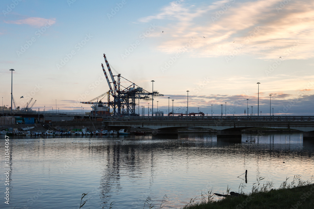 Container Terminal, Shipyard and Cranes at Sunset and Their Refl