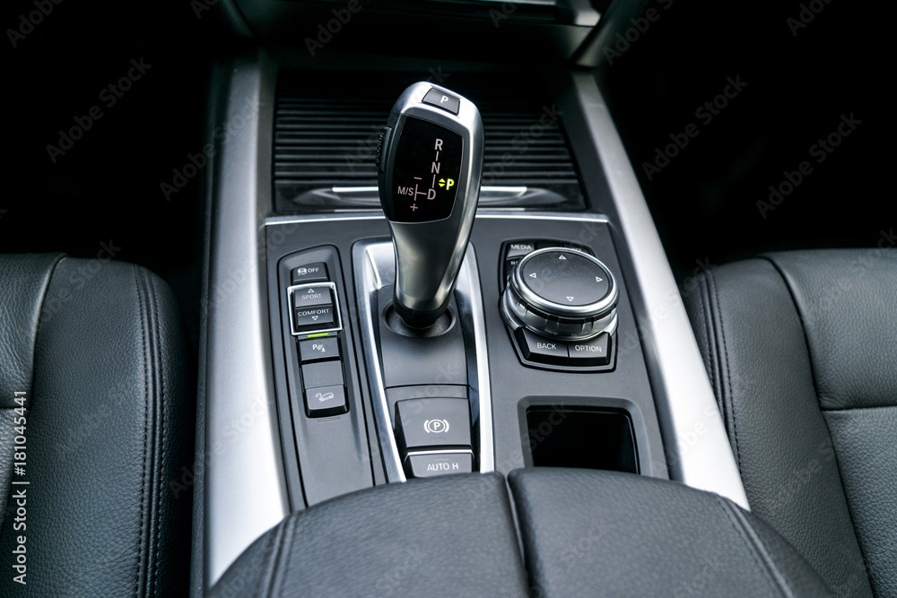 Automatic gear stick (transmission) of a modern car, multimedia and navigation control buttons. Car interior details. Transmission shift.