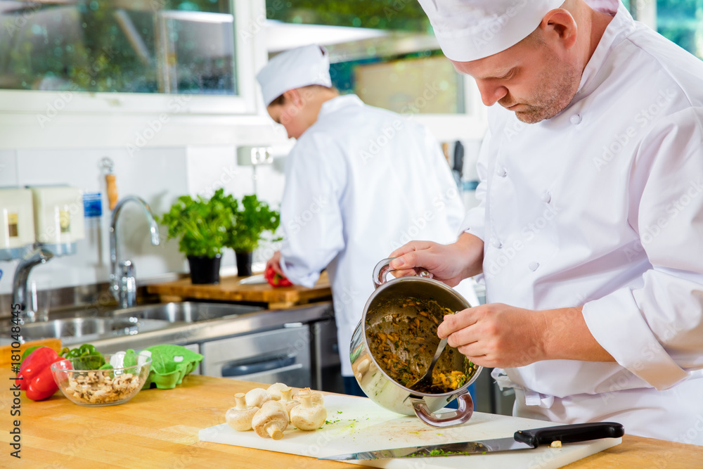Professional chefs makes food dishes in large kitchen Professional chefs makes food dishes in large kitchen