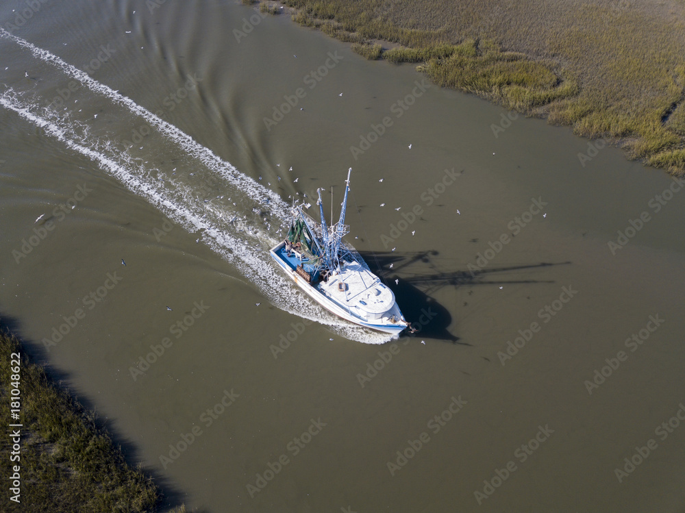Naklejka premium Aerial view of commerical fishing vessel coming into port.
