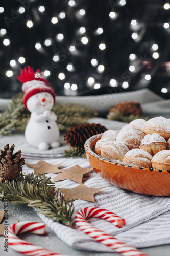 Christmas composition with a toy snowman, paper stars, cones, christmas candies and sweet crispy nuts filled with boiled condenced milk photo