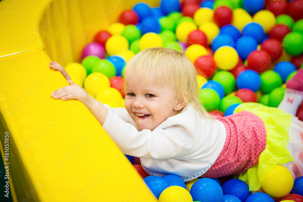 Obraz premium THE BABY IS PLAYING IN COLORED BALLS