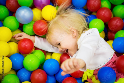 THE BABY IS PLAYING IN COLORED BALLS