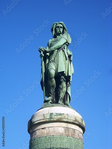 Fotografie, Obraz Statue de Vercingétorix sur fond de ciel bleu.