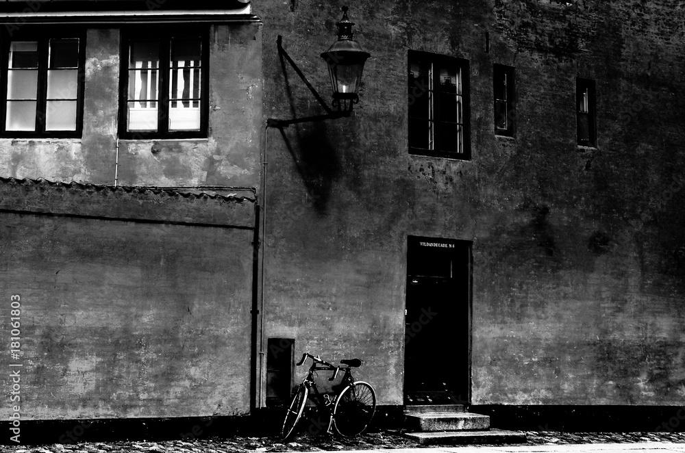 Fototapeta premium Black and white photo. Old house in Copenhagen, texture wall and bicycle near the door.