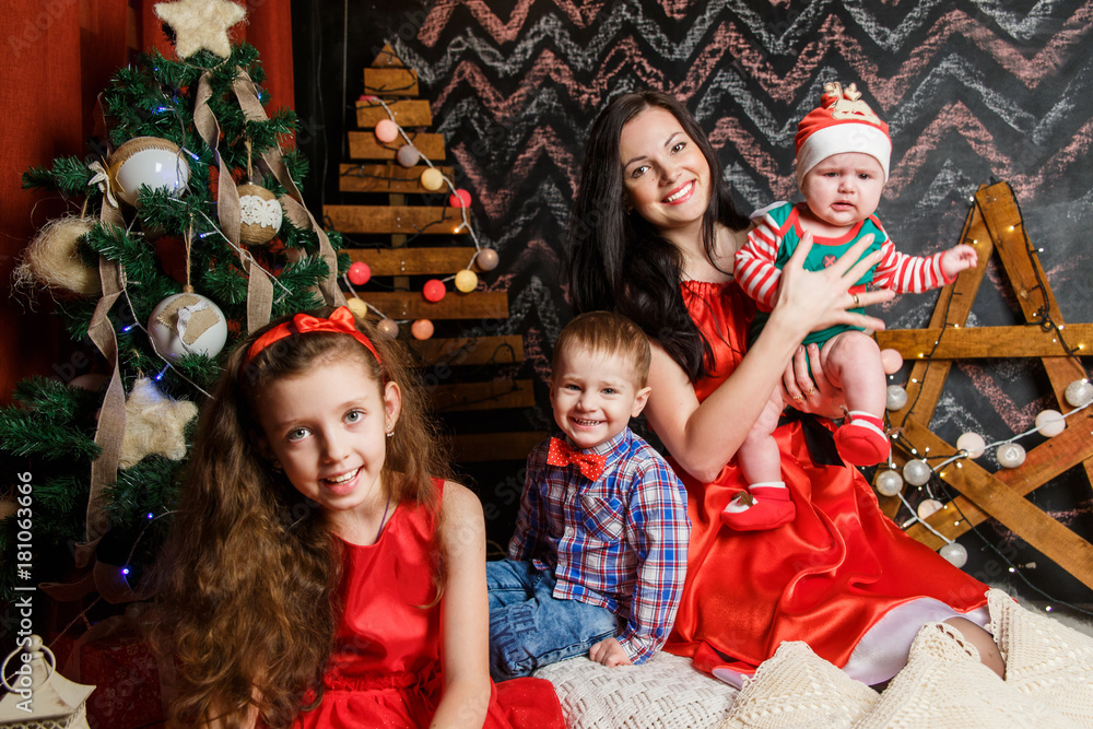 Fototapeta premium Mother with kids in a Christmas photo session