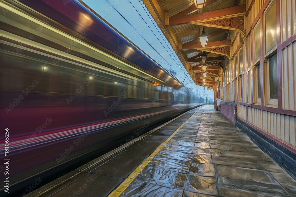 Express train passing through a Victorian station at speed