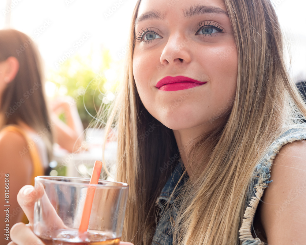 Happy young girl drinking a cocktail outdoor, during a sunny summer day Happy young girl drinking a cocktail outdoor, during a sunny summer day
