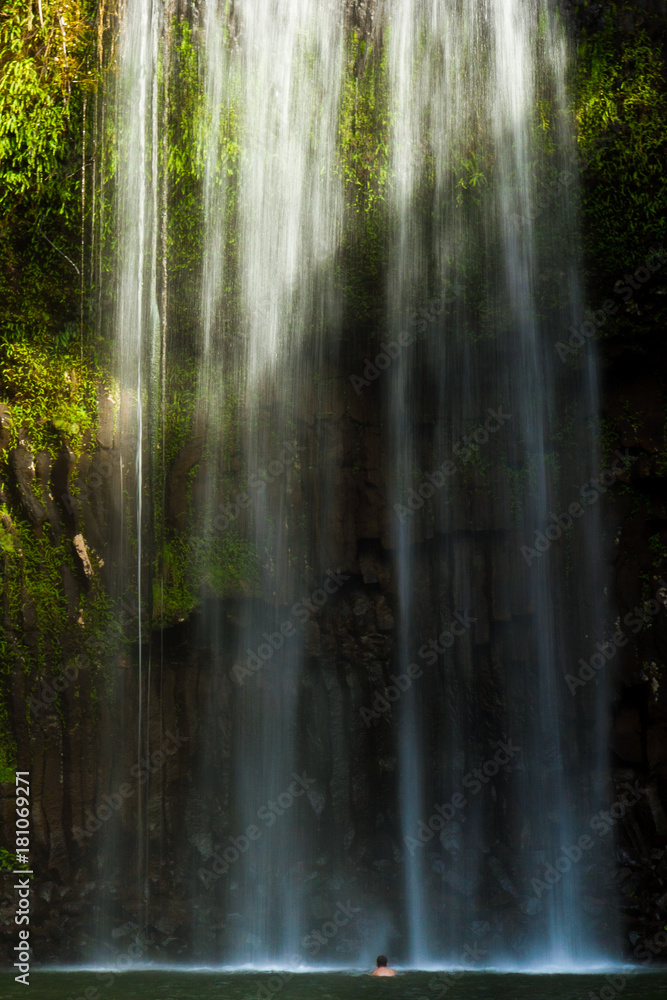 Fototapeta premium Man under sunlit waterfall (Northern Australia)