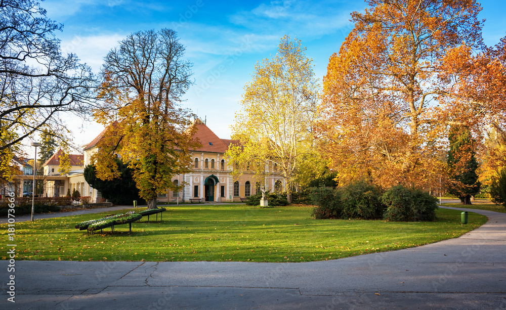 Fototapeta premium Autumn in Piestany (Slovakia) – park, historical building, colorful trees, blue sky