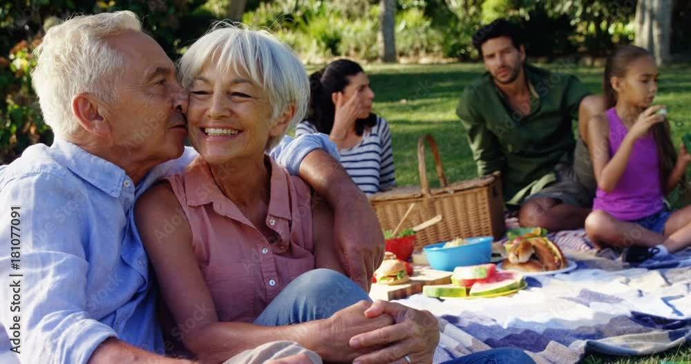 Affectionate senior couple sitting in park Affectionate senior couple sitting in park
