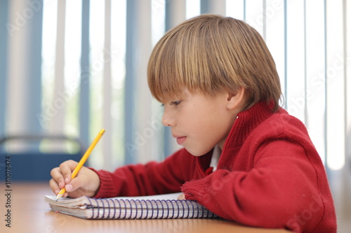 concertrated child doing home work at home photo