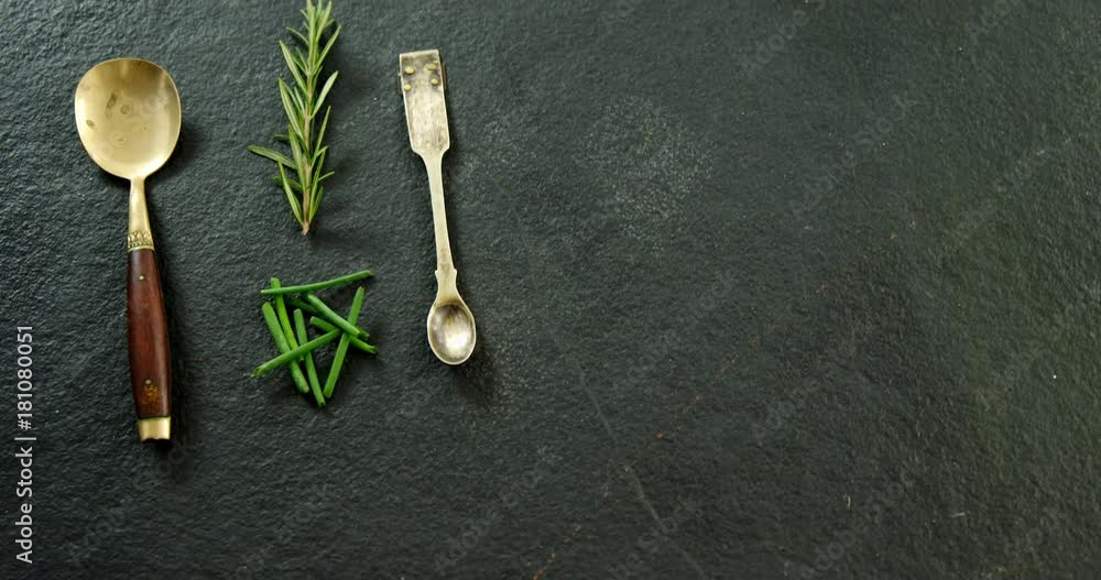 Two metal spoons with chives and rosemary Two metal spoons with chives and rosemary