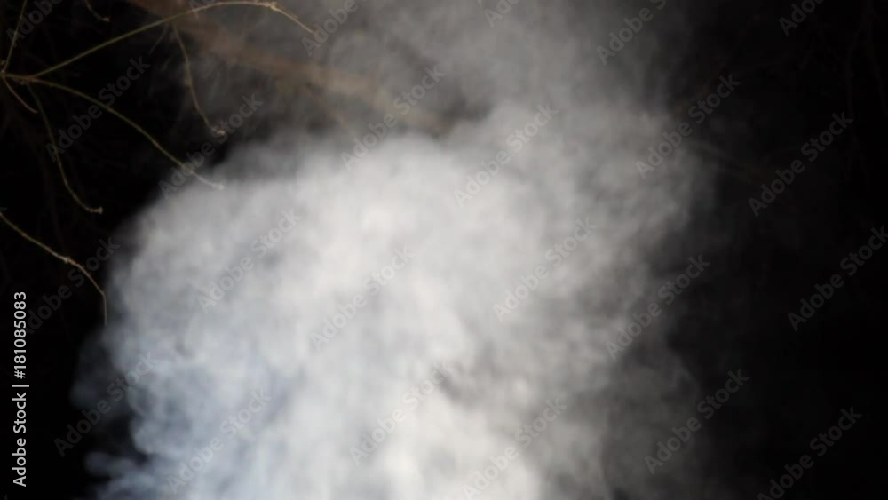 White smoke rises into the night on a black background White smoke rises into the night on a black background