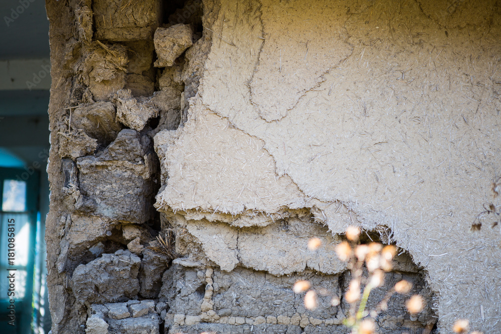 Fototapeta premium Part of Ruined old house. Ruins of a house made of shell rock, straw and clay in the village. Poor old village.