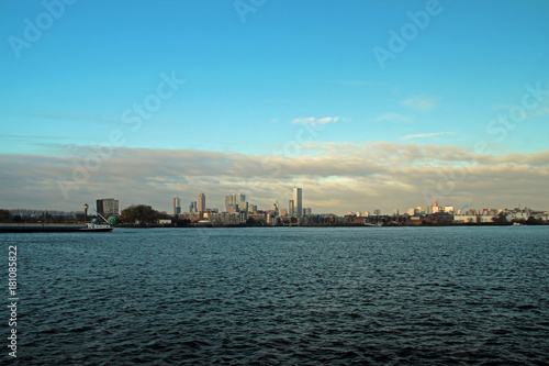Rotterdam skyline on the horizon with big cloud front above it with blue sky © André Muller