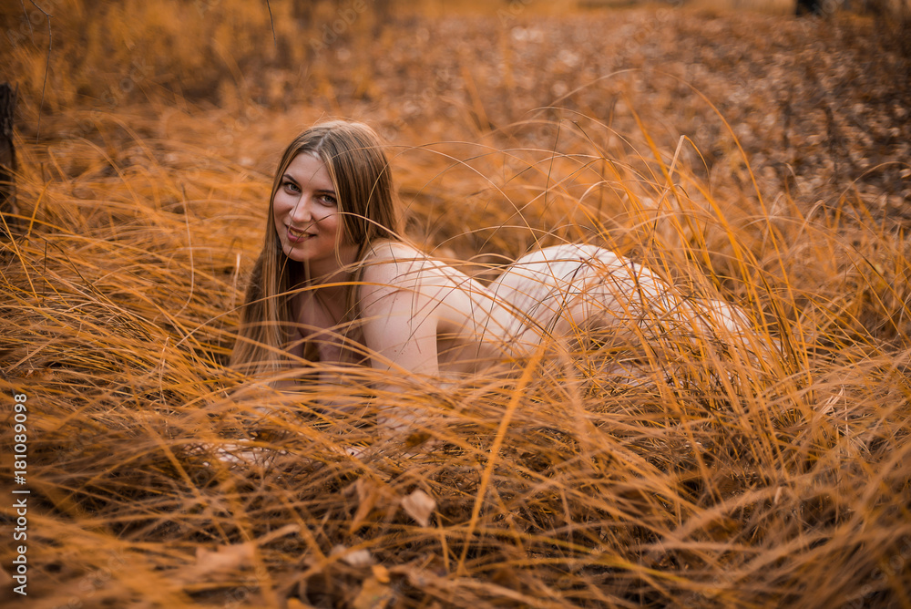 Young, sexy, plump naked girl with really big Breasts lying in the yellow grass in the forest. Autumn, overcast. Young, sexy, plump naked girl with really big Breasts lying in the yellow grass in the forest. Autumn, overcast.