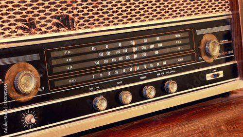 Close-up of vintage radio buttons and tuner control panel. Wooden brown antique retro old radio scale.