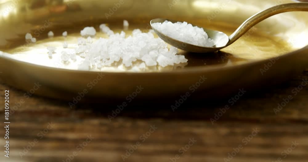 Salt in spoon and plate on wooden table Salt in spoon and plate on wooden table