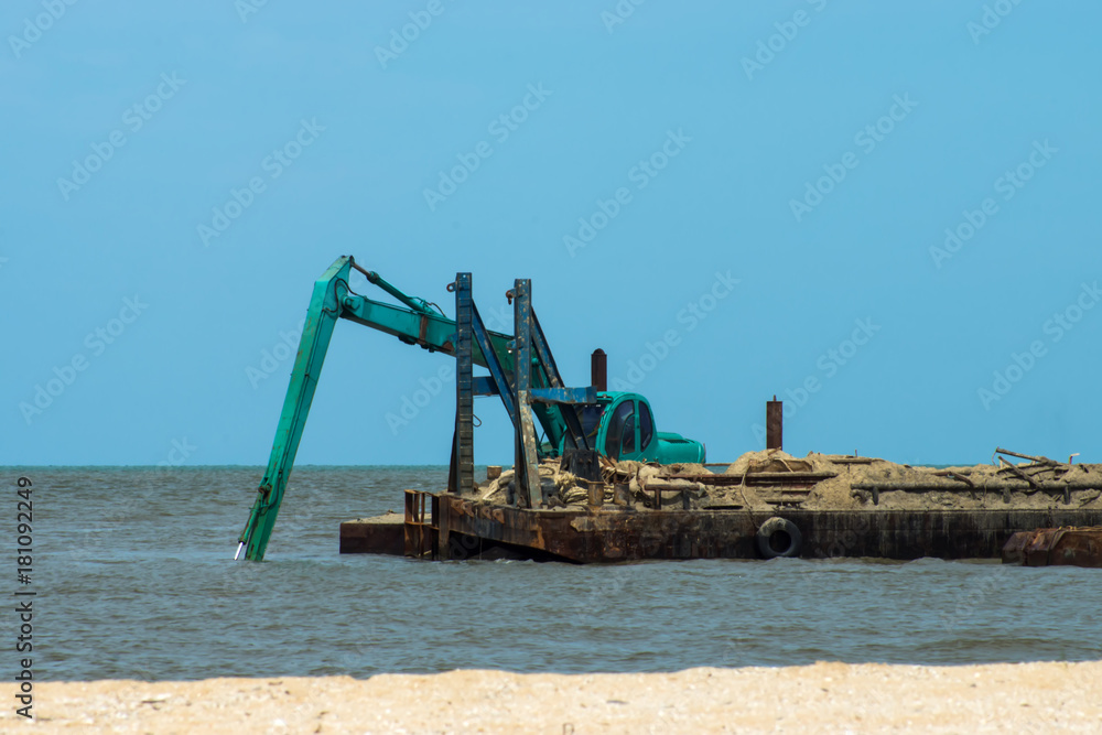 Machines are dredging sand in the sea.