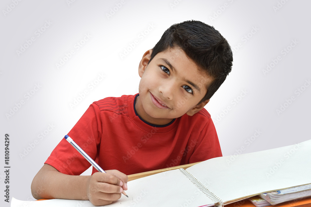 Indian kid smiling looking camera with pencil in hand drawing Indian kid smiling looking camera with pencil in hand drawing