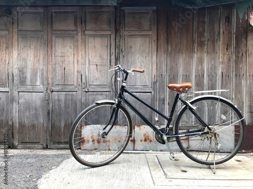 Black bike brown cushion The front door of the house and the old wooden wall is not painted with a simple life concept, exercise, love the world, fresh air, Life slow, travel, economical, healthy