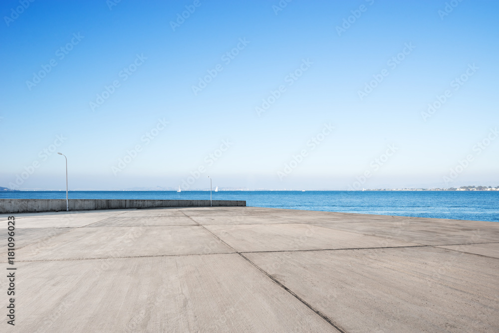 empty concrete floor with blue sea in blue sky