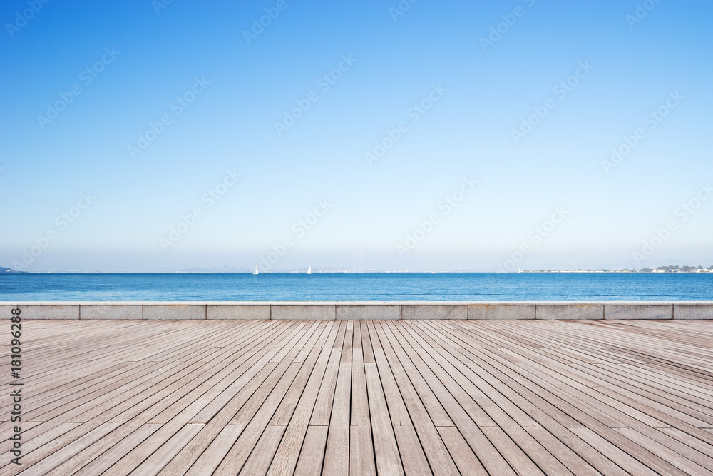 empty wooden floor with blue sea in blue sky