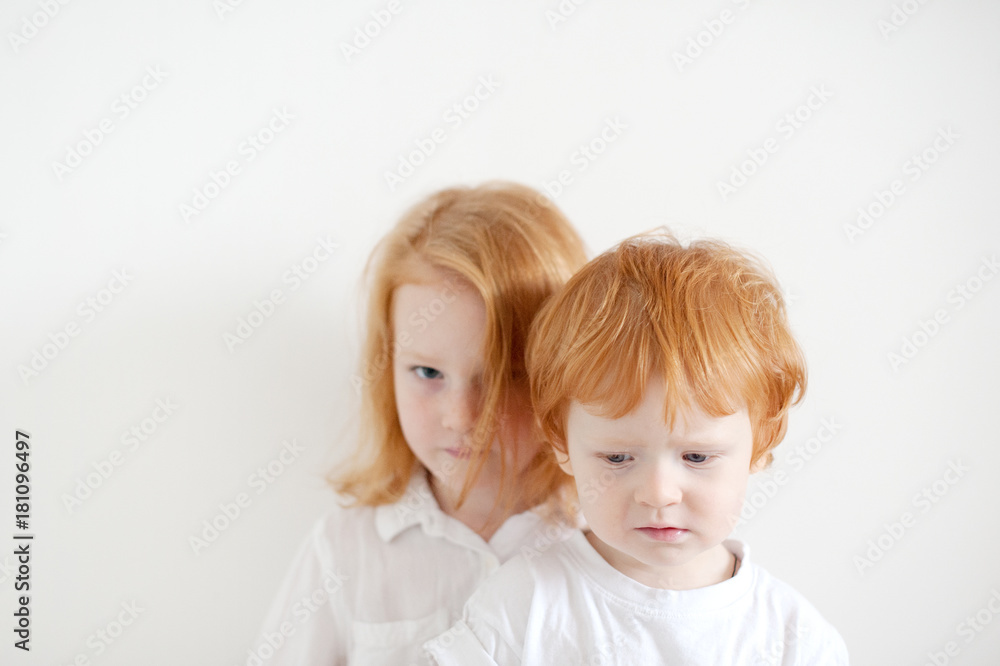 Upset red-haired children in white T-shirts Upset red-haired children in white T-shirts