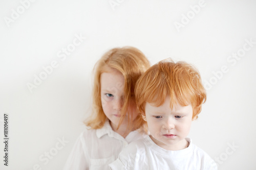 Upset red-haired children in white T-shirts