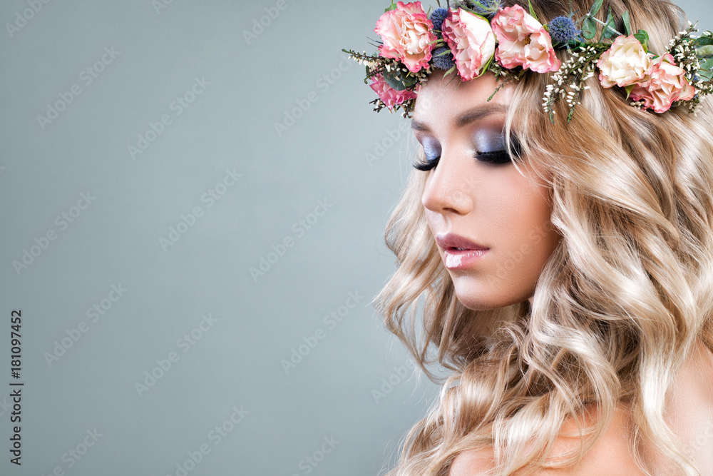 Cute Woman with Pink Roses Flowers and Green Leaves Wreath, Blonde Curly Hair and Healthy Skin. Skincare and Haircare Concept Cute Woman with Pink Roses Flowers and Green Leaves Wreath, Blonde Curly Hair and Healthy Skin. Skincare and Haircare Concept