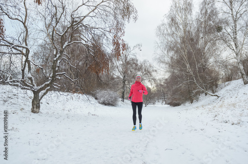 Winter running in park: happy active woman runner jogging in snow, outdoor sport and fitness concept   © Iuliia Sokolovska