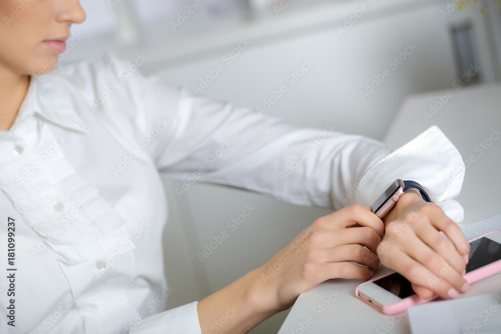 woman using smartwatch and working woman using smartwatch and working