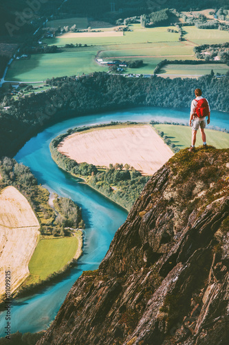 Man adventurer with backpack on cliff Travel lifestyle concept active weekend summer vacations tourist enjoying river aerial view