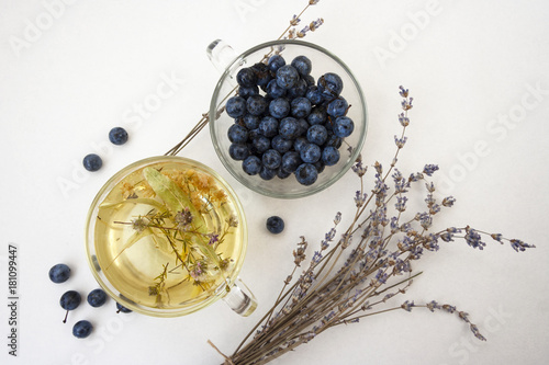 Blueberries and herbal tea in glass cups. The bouquet of lavender. Healthy breakfast. White background. Flat lay