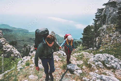 Couple Man and Woman holding hands hiking in mountains Love and Travel Lifestyle concept. Backpackers family traveling together active adventure vacations