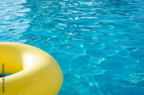 Yellow swim ring in a swimming pool with rippled water  background