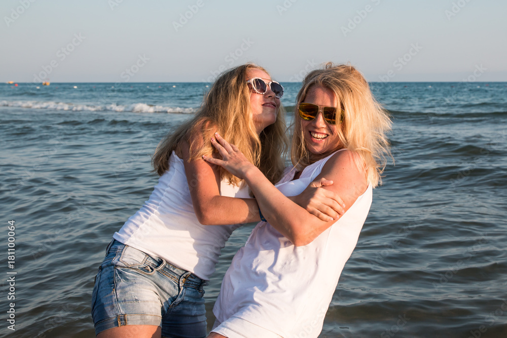 Two blond girls fighting in a water of a sea or ocean Two blond girls fighting in a water of a sea or ocean