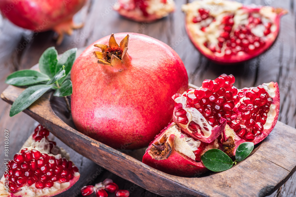 Ripe pomegranate fruits on the wooden background. Ripe pomegranate fruits on the wooden background.