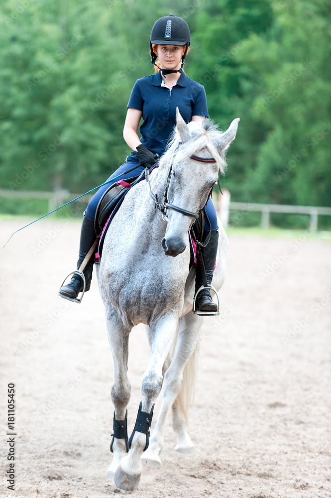 Young lady riding a horse at equestrian school. Training process Young lady riding a horse at equestrian school. Training process