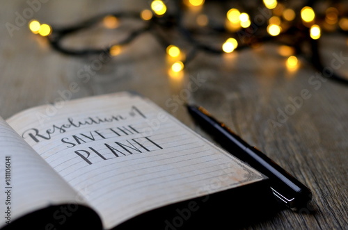 RESOLUTION No. 1 : SAVE THE PLANET brush calligraphy in notebook with bokeh lights