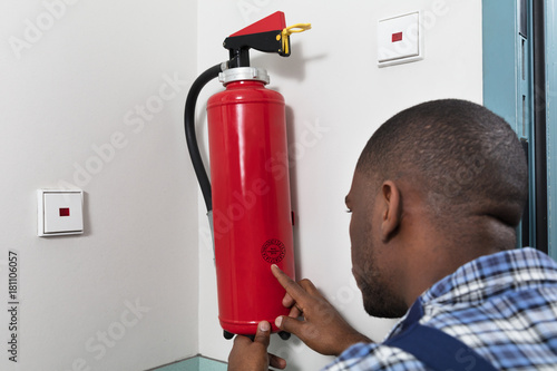 Male Professional Checking A Fire Extinguisher