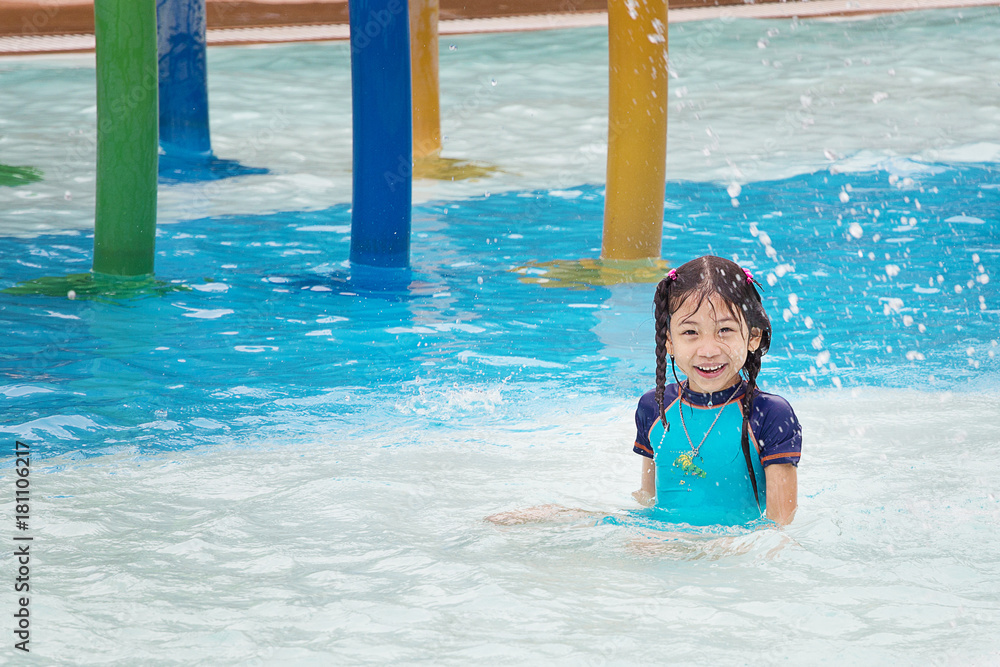 Little girl happily playing in water park vacations summer holiday Little girl happily playing in water park vacations summer holiday